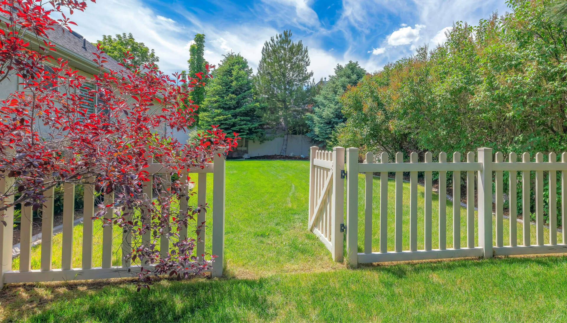 A functional fence gate providing access to a well-maintained backyard, surrounded by a wooden fence in Staten Island
